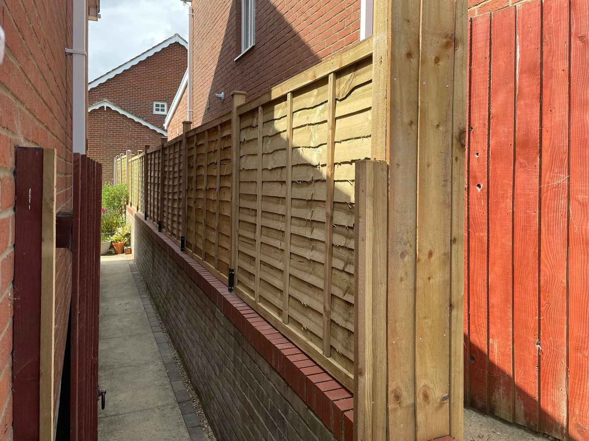 Closeboard fence on wall at side of house.